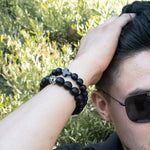 Load image into Gallery viewer, Real Shungite Bracelet with Cross, 10mm bead - on a model wearing 2 Shungite bracelets, sold separately - BellaChel Jeweler
