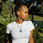 Cargar imagen en el visor de la galería, Laguna Collection - Beautiful Blue Turquoise and Pyrite Pendant weaved in Sterling Silver on a model - BellaChel Jeweler
