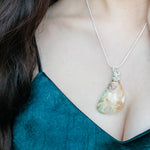 Load image into Gallery viewer, Laguna Collection - Tan and Teal pendant in Sterling Silver on a model - BellaChel Jeweler
